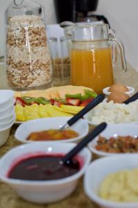a table topped with bowls of food and a pitcher of orange juice at Pepe's House Cuenca I Hotel & Boutique Hostel in Cuenca