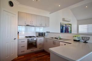 a kitchen with white cabinets and a counter top at Flinders View in Augusta