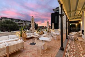 a patio with white couches and tables and umbrellas at The Albert Mosman in Sydney