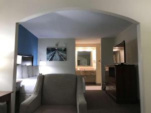 una habitación de hotel con una cama y una silla en una habitación en Best Western Inn & Suites Monroe, en Monroe
