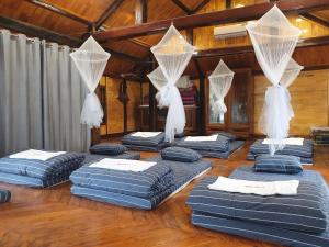 een kamer met 4 blauwe matrassen op een houten vloer bij Ben's Home in Mai Chau