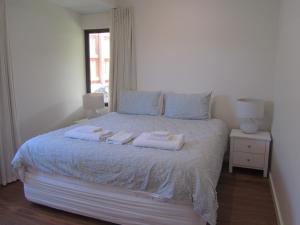 een slaapkamer met een bed met twee handdoeken erop bij Storm Bay Cottage in Augusta