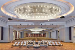 einen großen Bankettsaal mit Stühlen und einem großen Kronleuchter in der Unterkunft Miracle Grand Convention Hotel in Bangkok