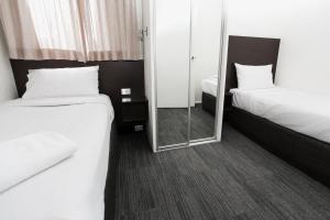 um quarto de hotel com duas camas e um espelho em St Ives Apartments em Hobart