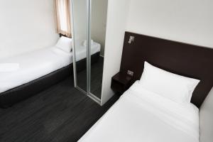 
a hotel room with a bed and a mirror at St Ives Apartments in Hobart
