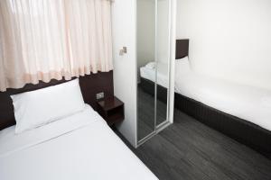 Habitación de hotel con cama y espejo en St Ives Apartments en Hobart