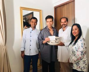 a group of men and a woman holding a cake at The Postcard Cuelim, Goa in Cansaulim