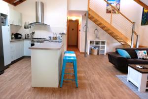 a kitchen and living room with a counter and a stool at Sea Esta - town & beach on your doorstep in Dunsborough
