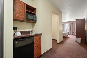 a kitchen with a sink, stove, microwave and refrigerator at Stay USA Hotel and Suites in Hot Springs