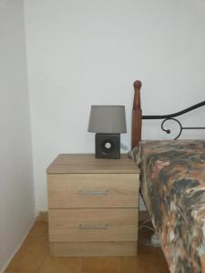 a night stand with a lamp on top of a bed at George's Country House in Kamilari