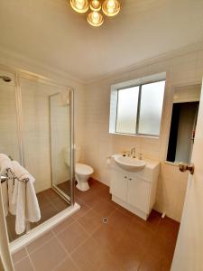 
a bathroom with a tub, toilet and sink at Largs Pier Hotel in Adelaide
