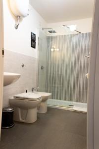 y baño con aseo, lavabo y ducha. en ArtHouse Termini, en Roma