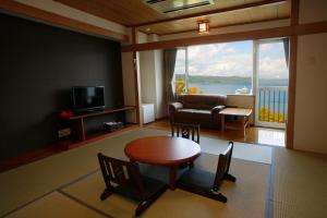 
a living room filled with furniture and a tv at Granvillage Toya Daiwa Ryokan Annex in Lake Toya
