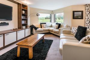 a living room with two couches and a tv at Golf Apartment @ Carus Green in Kendal