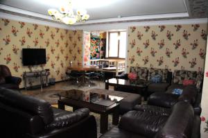 a living room with leather couches and a tv at ARTANOR in Tashkent