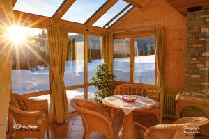 Zimmer mit einem Tisch, Stühlen und einem Fenster in der Unterkunft Ferienwohnung Moser in Mariapfarr