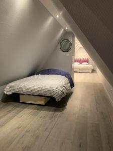 ein Schlafzimmer mit einem Bett in der Ecke eines Dachbodens in der Unterkunft Gîte du Figuier 4 à 6 personnes Sélestat Centre-Alsace in Sélestat
