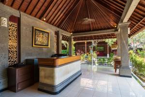 an outdoor bar in a house with a roof at Amatara Agung Raka in Ubud