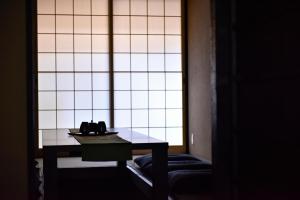a table in a room with a large window at Rinn Premium Machiya Koki in Kyoto
