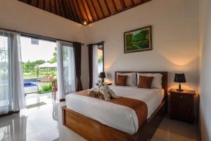 Un dormitorio con una cama y una ventana grande. en Tunjung Kuning Cottage, en Nusa Penida 38 fotos más