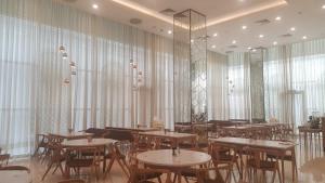 a restaurant with tables and chairs in a room with windows at Citadines Regency Saigon in Ho Chi Minh City