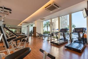 a gym with a lot of treadmills and ellipticals at Rembrandt Hotel and Suites SHA Plus Certified in Bangkok