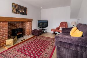 sala de estar con sofá y chimenea en 1 Roseanna Cottage, Middleton, en Middleton