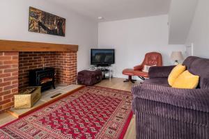 a living room with a couch and a fireplace at 1 Roseanna Cottage, Middleton - Aldeburgh Coastal Cottages in Middleton