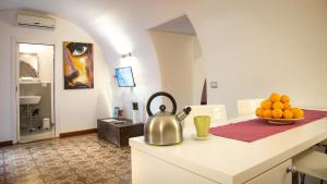 a kitchen with a tea kettle and a bowl of fruit on a counter at The House in Catania