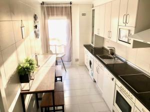 a kitchen with white cabinets and black counter tops at Apartamento Turístico El Enclave in Olite