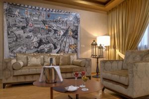 een woonkamer met een bank en 2 tafels met wijnglazen bij Hotel Rua Frati 48 in San Francesco in Modena