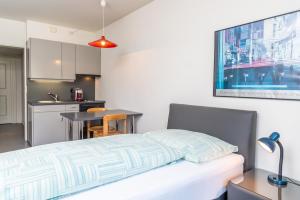 Face Aparthotel في دافوس: غرفة نوم بسرير ومطبخ