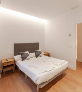 1 dormitorio con 1 cama con sábanas y almohadas blancas en Modern Apartment Gran Via IV Renovated 5BR 5BH, en Madrid
