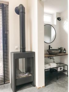 een zwarte open haard in een kamer met een spiegel bij ForRest Suites in Ermelo