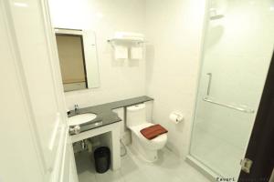 a bathroom with a toilet and a sink and a shower at Favori Hostel Bangkok Surawong in Bangkok