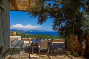Una mesa y sillas en un patio con vista al agua. en Villa Atokos, en Sivota