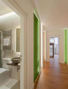 a bathroom with a green accent wall at Luxury flat Gran Via III in Madrid