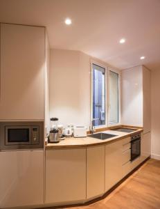 cocina con fregadero y microondas en Modern Apartment Gran Via IV Renovated 5BR 5BH, en Madrid