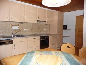 cocina con mesa, fregadero y fogones en Ferienwohnung Weber, en Freyung