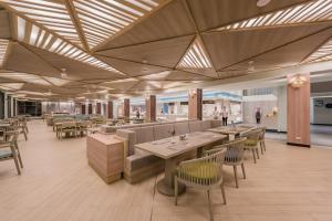 a restaurant with tables and chairs in a room at Oceanfront Beach Resort - SHA Extra Plus in Patong Beach