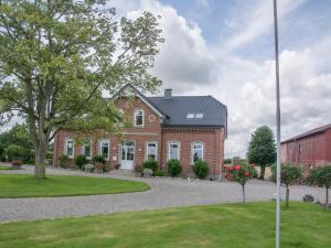 una grande casa in mattoni con un albero di fronte di Landurlaub Regenholz a Kronsgaard