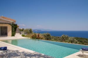 a swimming pool with a view of the ocean at Villa Koumaria in Sivota