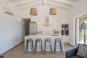 a kitchen with a large white island with bar stools at Villa Koumaria in Sivota