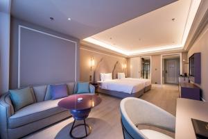 a hotel room with a bed and a couch at Mercure Hotel Changchun Hengxing in Changchun +46 photos