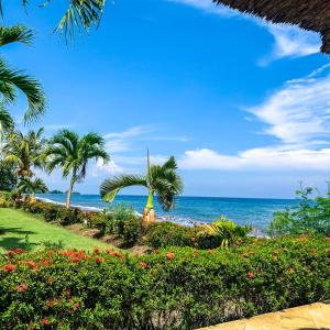 - une vue sur la plage bordée de palmiers et l'océan dans l'établissement Villa Cahaya - Bali Sea Villas Beachfront and private pool, à Pengastulan