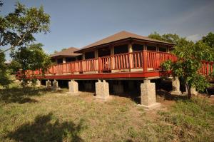 a large wooden house with a deck on top at Elephant Rock Luxury Camp Tarangire in Kaiti
