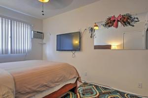 a bedroom with a bed and a flat screen tv at Downtown Long Beach Condo - 1 Mi to Boardwalk! in Long Beach