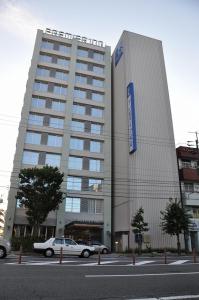 a white car parked in front of a building at Smile Hotel Matsuyama in Matsuyama