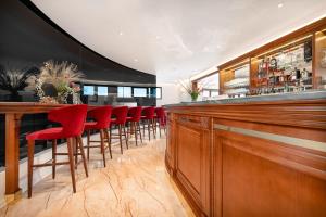 a bar with red bar stools in a restaurant at Hotel Cvita in Split