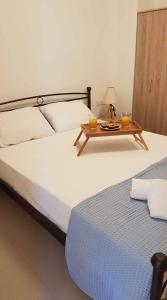 un letto con un tavolo con due bicchieri sopra di Marina Deluxe Apartments a Istron
